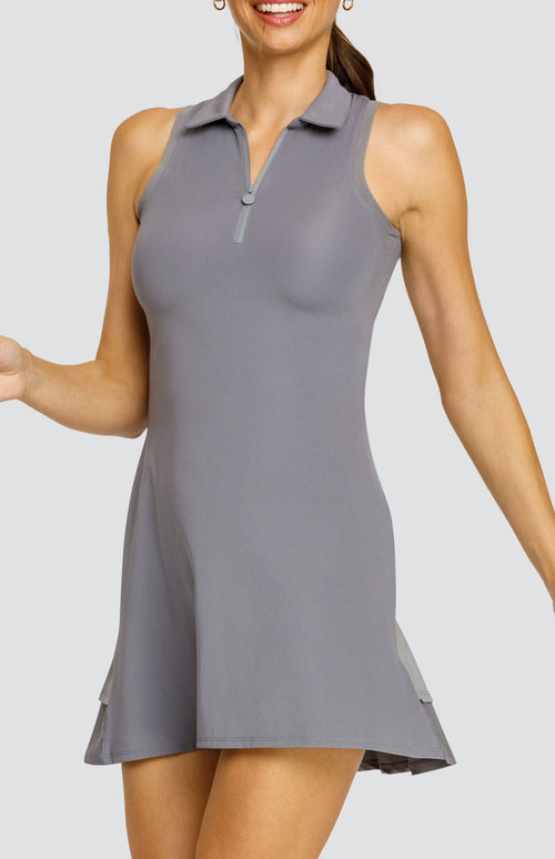 Model wearing a gray sleeveless dress with a quarter zip foldover collar and a double ruffle in the back.