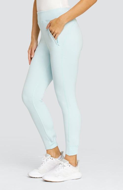 Model wearing a light blue ankle length jogger with a waistband, welt pockets, and ribbed back ankle cuffs.