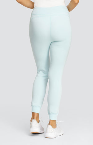 Model wearing a light blue ankle length jogger with a waistband, welt pockets, and ribbed back ankle cuffs.