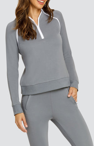 Model wearing a gray long sleeve sweatshirt with a quarter zip neckline, white piping accents, and ribbed hem and cuffs. Paired with a matching jogger with welt pockets.