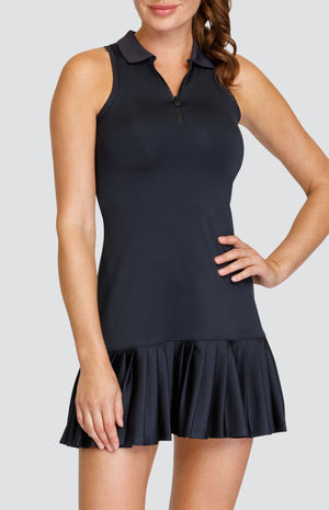 Model wearing a black quarter zip dress with a foldover collar and pleated hem.