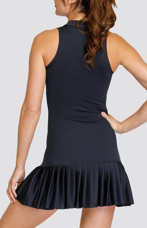 Model wearing a black quarter zip dress with a foldover collar and pleated hem.