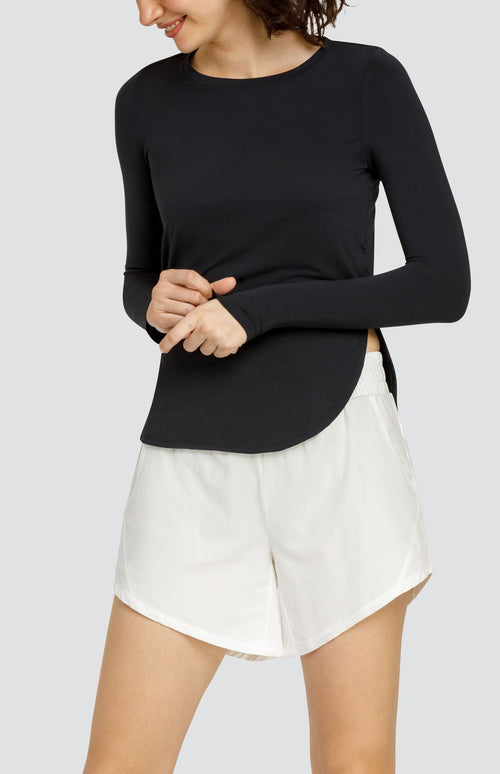 Model wearing a long sleeve top with high side slits and white shorts with elastic waistband and pockets.