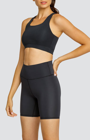 Model wearing a black scoop neck sports bra and black high rise leggings.