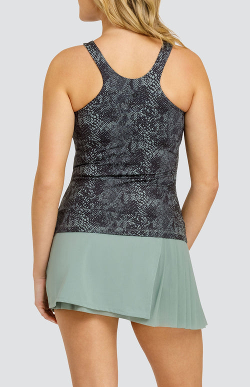 Model wearing a high neck medium support tank top in a snakeskin print, paired with a solid sage green skort with a mesh asymmetrical pleat panel.