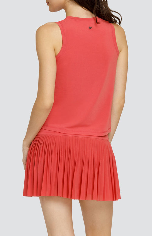 Model wearing coral hi-low swing tank top and coral micro pleated mesh skort.