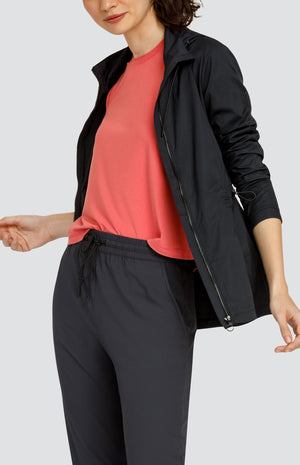 Model wearing a coral hi-low swing tank top, black hooded jacket with zipper and drawstring waist, and black joggers with elastic drawstring waistband and pockets.