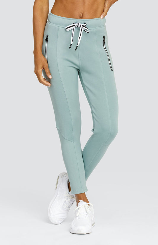 Model is wearing a light Sage Green jogger with drawstring waist and side zipper pockets. 