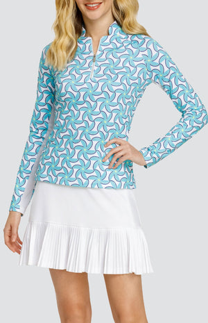 Model wearing a long sleeve top with spiral floral pattern in turquoise and blue on a white background, and a solid white skort.