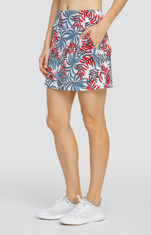 Model wearing a pull-on golf skort with a red and blue palm frond print on a white background.