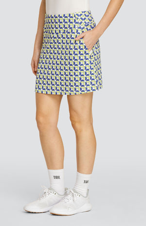 Model wearing a pull-on golf skort with a geometric circular pattern in blue and yellow on a white background.