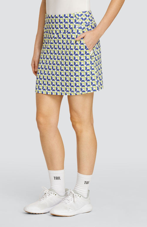 Model wearing a pull-on golf skort with a geometric circular pattern in blue and yellow on a white background.