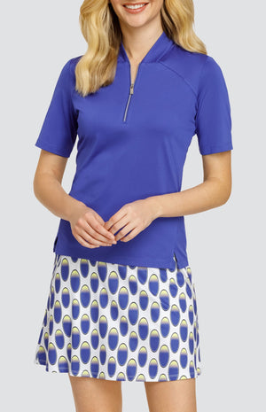 Model wearing a solid blue short sleeve top and a pull-on golf skort with an oval pattern in blue and yellow on a white background.