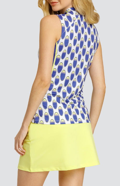 Model wearing a sleeveless top with an oval pattern in blue and yellow on a white background, and a solid yellow golf skort.