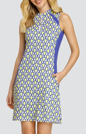 Model wearing a sleeveless golf dress with a teardrop pattern in yellow, blue, and white with blue inserts.