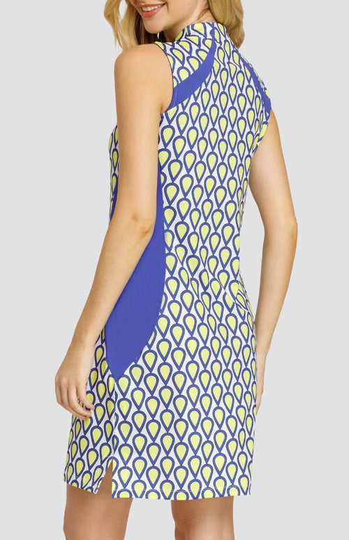 Model wearing a sleeveless golf dress with a teardrop pattern in yellow, blue, and white with blue inserts.