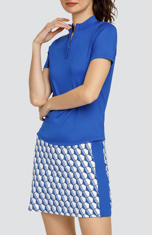 Model wearing a pull on skort with a blue and white hexagon pattern and matching solid blue short sleeve top;