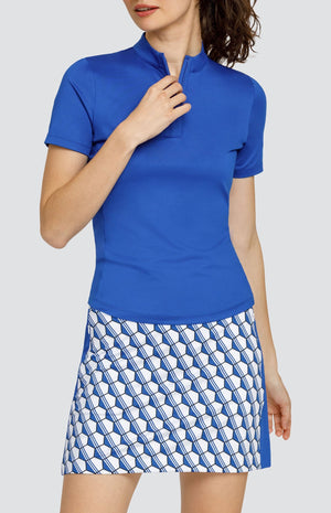 Model wearing a short sleeve solid blue top and a skort with a blue and white hexagon pattern.