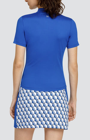 Model wearing a short sleeve solid blue top and a skort with a blue and white hexagon pattern.