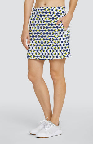 Model is wearing 18" pull on, performance jersey skort in "Nova Rush" pattern. Geometric styled pattern with Lakestorm blue, Dandelion yellow, and Chalk white. Skort has two zipper side pockets. 