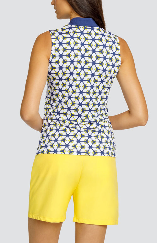 Model is wearing a sleeveless performance jersey top with a novelty collar. The top is in print "Jewel Twist" showing a geometric pattern of Lakestorm blue, Dandelion yellow, and Chalk white. 