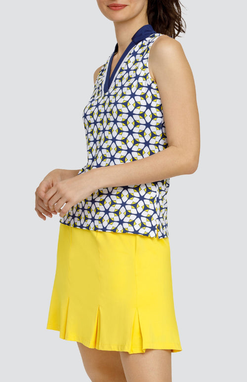 Model is wearing a sleeveless performance jersey top with a novelty collar. The top is in print "Jewel Twist" showing a geometric pattern of Lakestorm blue, Dandelion yellow, and Chalk white. 