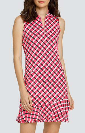 Model wearing a sleeveless quarter-zip golf dress in a pink 3-dimensional block pattern.