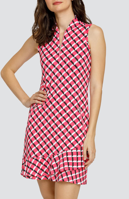 Model wearing a sleeveless quarter-zip golf dress in a pink 3-dimensional block pattern.