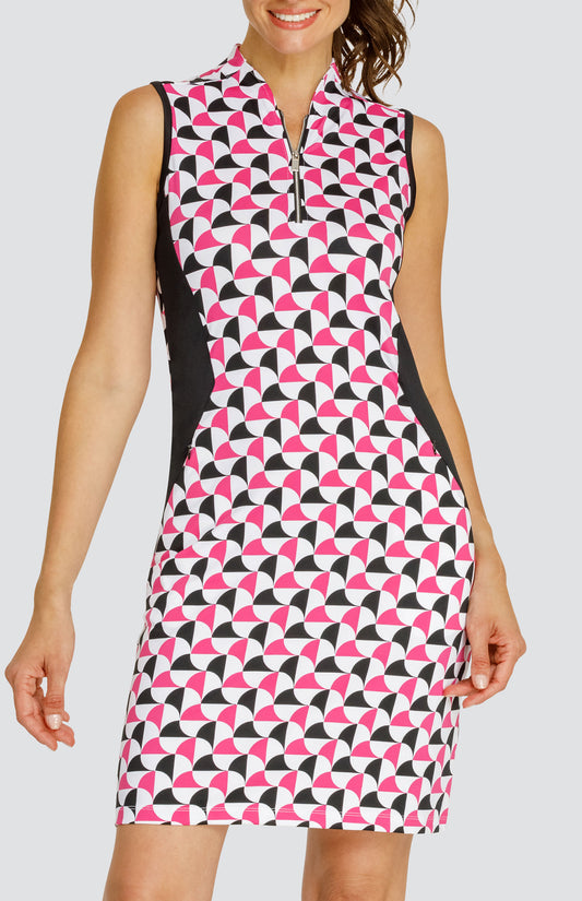 Model wearing a sleeveless quarter-zip golf dress in a pink and black alternating triangular print on a white background with black side inserts.