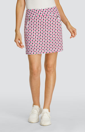 Model wearing a pull-on golf skort in a pink and black geometric alternating diamond print on a white background.