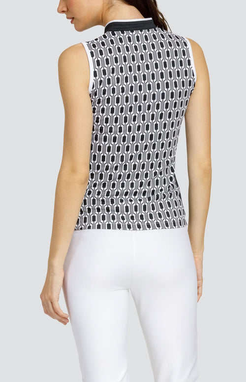 Model wearing a sleeveless golf top with a chain link style black and white print, with black side inserts.