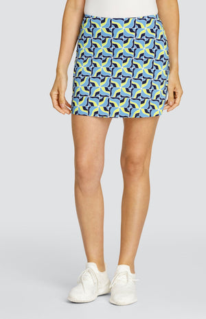 Model wearing a pull on tennis skort with a light blue and neon yellow abstract grid pattern.